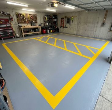 Szara posadzka garażowa z wyznaczonym strefowaniem za pomocą pasów w intensywnym kolorze żółtym RAL 1021.